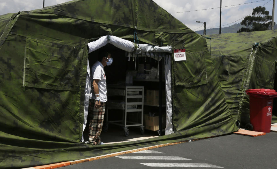 A COVID-19 patient looks for a relative to bring him personal items, from inside a tent set up outside the Social Security Hospital where patients are being treated in Quito, Ecuador, Thursday, April 22, 2021. The government decreed new lockdown rules on April 21 for the majority of Ecuador's provinces, limiting movement on weeknights and an all-day curfew on weekends to curb the spread of the new coronavirus which is overwhelming hospitals. (AP Photo/Dolores Ochoa)