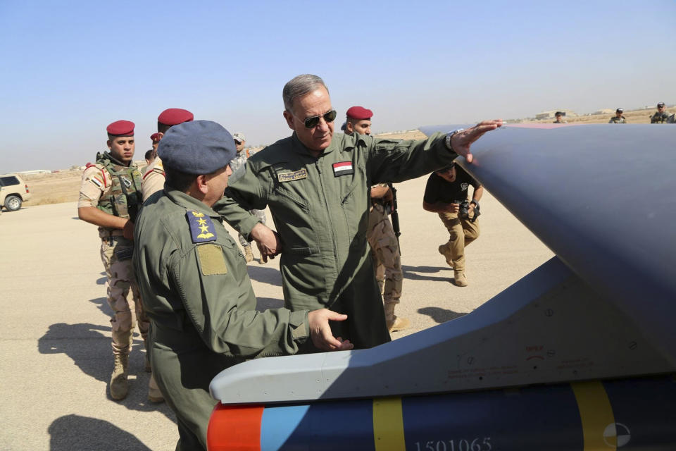 FILE - In this Oct. 10, 2015, file photo, Iraqi Defense Minister Khaled al-Obeidi, center, inspects a first Chinese drone to be used by the Iraqi Air Force before sending it to bomb Islamic State group positions at an airbase in Kut, 160 kilometers (100 miles) southeast of Baghdad, Iraq. Across the Middle East, countries locked out of purchasing U.S.-made drones due to rules over excessive civilian casualties are being wooed by Chinese arms dealers, who are world's main distributor of armed drones. The sales are helping expand Chinese influence across a region crucial to American security interests and bolstering Beijing's ambitions of being a world leader in high-tech arms sales. (AP Photo, File)