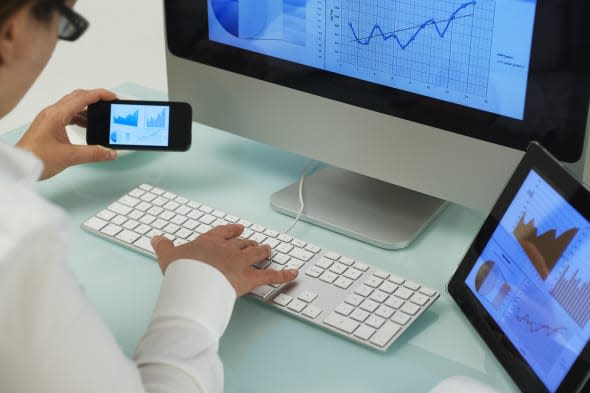 Multiple digital devices being used at office desk