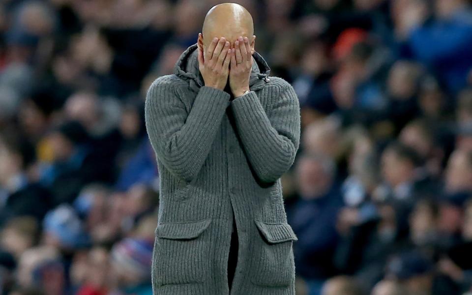 Pep Guardiola holds head in hands wearing knitted coat - REX