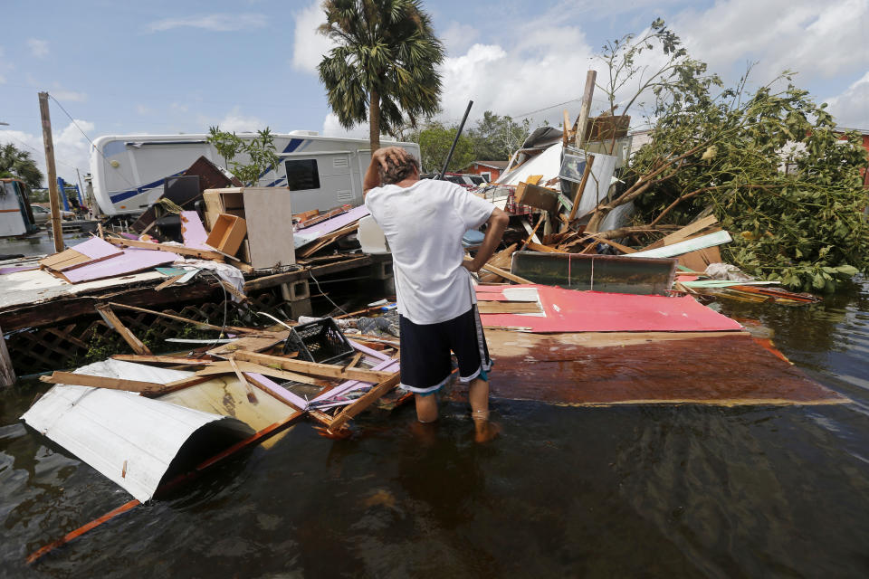 <p>Larry Dimas walks around his destroyed trailer, which he rents out to others, in the aftermath of Hurricane Irma in Immokalee, Fla., Sept. 11, 2017. (Photo: Gerald Herbert/AP) </p>