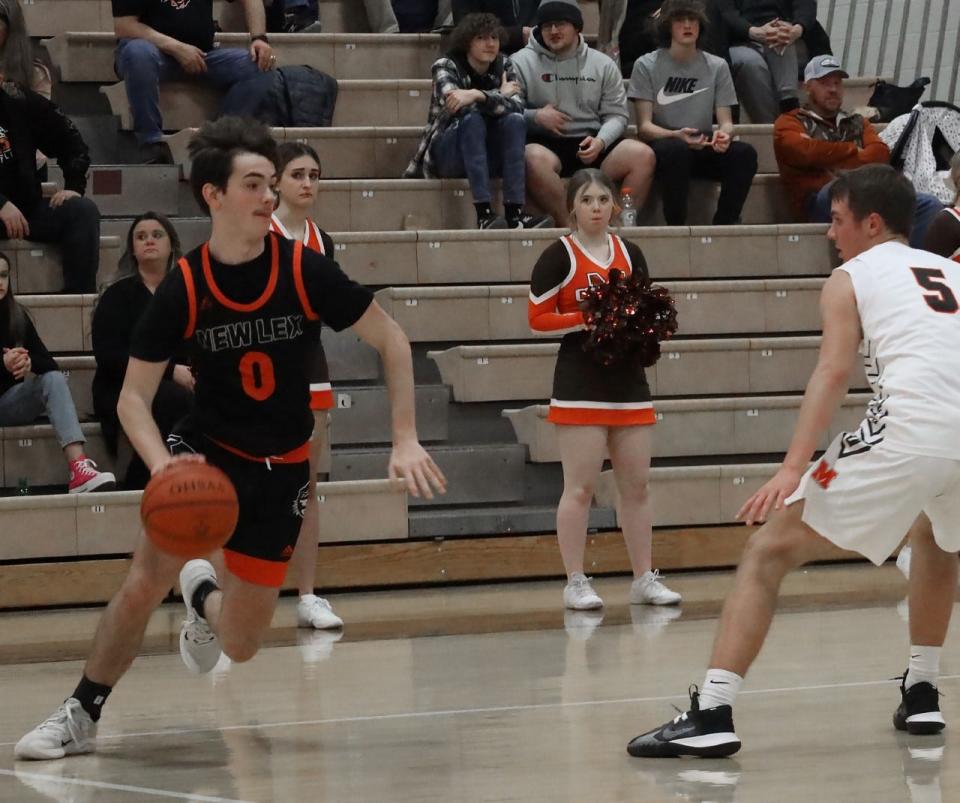 New Lexington junior Jerek Braglin (0) makes a love on Meadowbrook sophomore Colton Delancey (5) during Friday's MVL contest at Meadowbrook High School.