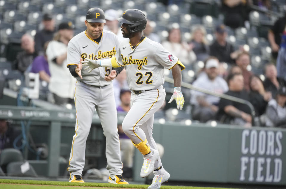 Pittsburgh Pirates right fielder Andrew McCutchen (22) is congratulated by third base coach Mike Rabelo as he circles the bases after hitting a solo home run in the first inning of a baseball game against the Colorado Rockies, Monday, April 17, 2023, in Denver. (AP Photo/David Zalubowski)