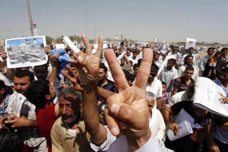 Supporters of Muqtada al-Sadr flash signs during a demonstration against the possibility of a U.S. military strike against the Syrian government, in Najaf