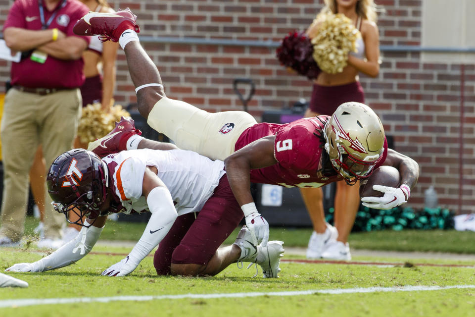 Florida State running back Lawrance Toafili (9) tumbles over Virginia Tech cornerback Mansoor Delane (4) for a second touchdown during the first half of an NCAA college football game, Saturday, Oct. 7, 2023, in Tallahassee, Fla. (AP Photo/Colin Hackley)