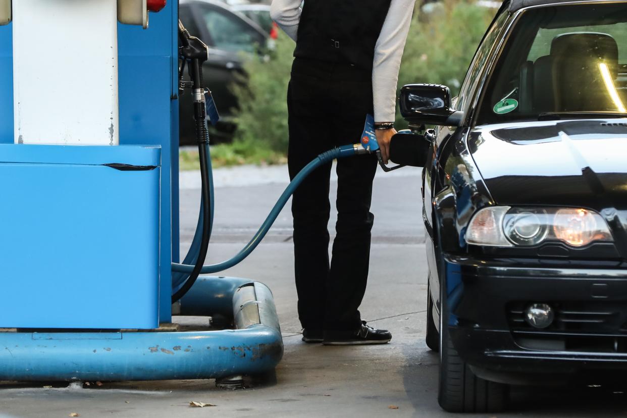 Mann tankt sein Auto an einer Tanksäule auf