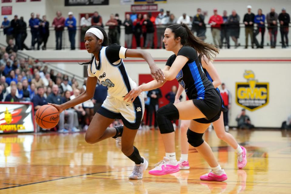 Mount Notre Dame Cougars small forward Laila Harrison (0) drives to the basket as Springboro Panthers guard Carly Turman (32) defends in the first half of an OHSAA Division I girls regional final game, Saturday, March 9, 2024, at Lakota West High School in West Chester Township, Ohio.