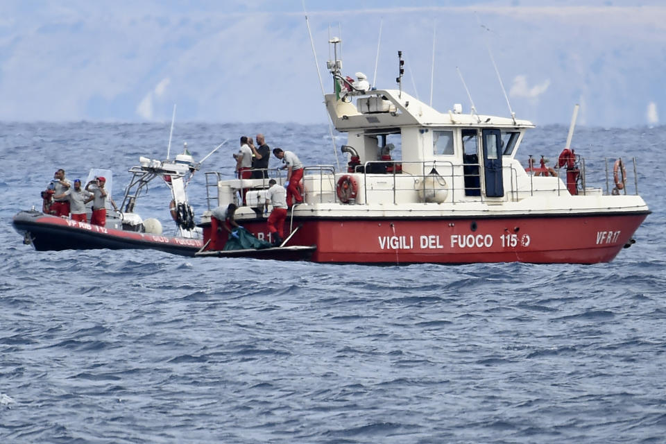 Italian Firefighters scuba divers bring ashore in a green bag the body of one of the victims of the UK flag vessel Bayesian, Wednesday, Aug. 21, 2024. The sail yacht was hit by a violent sudden storm and sunk early Monday, while at anchor off the Sicilian village of Porticello near Palermo, in southern Italy. (AP Photo/Salvatore Cavalli)