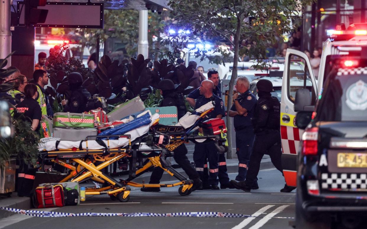 Paramedics push stretchers into the Westfield Bondi Junction shopping centre