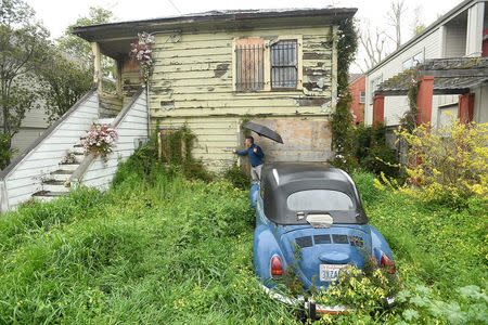 Emeryville Vice-Mayor John Bauters examines paint at a neglected property in Emeryville, California, United States March 20, 2017. "It's very likely this house has lead paint," said Bauters. To match Special Report USA-LEAD/CALIFORNIA REUTERS/Noah Berger