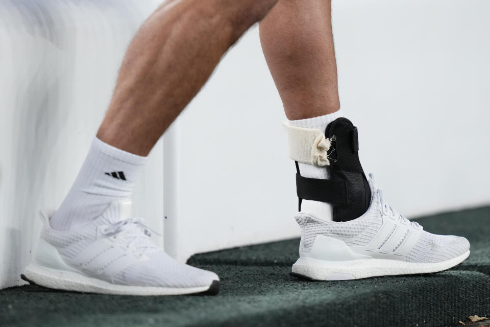 New York Jets quarterback Aaron Rodgers wears a brace around his left ankle while sitting on the bench before an NFL football game between the Jets and the Kansas City Chiefs, Sunday, Oct. 1, 2023, in East Rutherford, N.J. (AP Photo/Frank Franklin II)