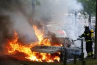 <p>A firefighter works at the scene where a number of cars burnt down during the G20 summit in Hamburg, Germany, July 7, 2017. (Photo: Hannibal Hanschke/Reuters) </p>