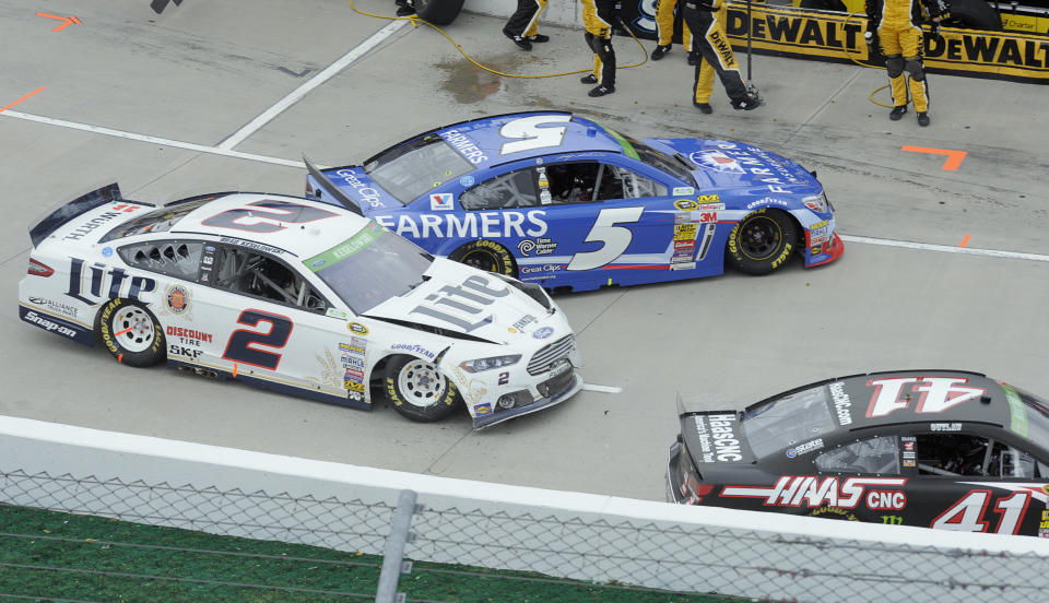 Brad Keselowski's (2) car is damaged in a pit road accident with Kasey Kahan (5) and Kurt Busch (41) during a NASCAR Sprint Cup Series auto race at Martinsville Speedway in Martinsville, Va., Sunday, March 30, 2014. (AP Photo/Mike McCarn)