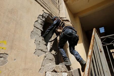 Iraqi Federal Police moves through a hole at Bab al Jadid district as the battle against Islamic State's fighters continues in the old city of Mosul, Iraq, March 26, 2017. REUTERS/Youssef Boudlal - RTX32RS4