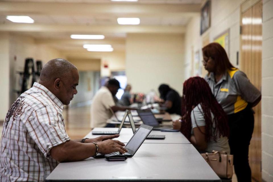 Job seekers fill out applications with Charlotte-Mecklenburg Schools at the Operations Hiring Event on August 3, 2022 at Phillip O’Berry High School in Charlotte, NC.