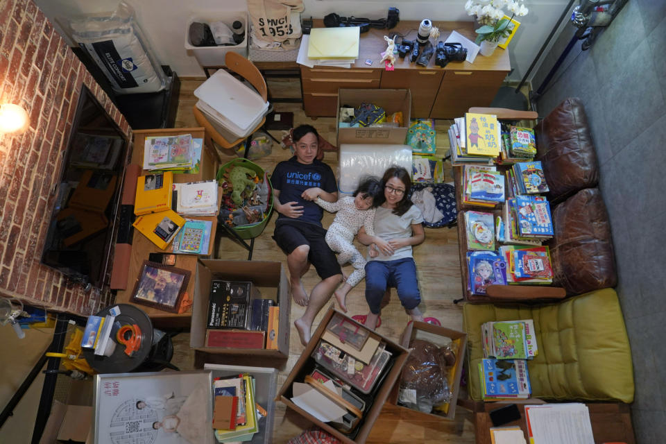 Mike Hui, left, poses with his family in Hong Kong as they are packing their house for moving to England, on March 9, 2021. Until early April, Hui was a photojournalist for the Apple Daily, a pro-democracy newspaper that shut down following the arrest of five top editors and executives and the freezing of its assets under a national security law that China's ruling Communist Party imposed on Hong Kong as part of the crackdown. (AP Photo/Kin Cheung)