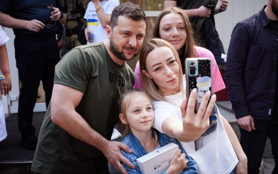 Volodymyr Zelensky has a selfie with a family forced out of their home - UKRAINIAN PRESIDENTIAL PRESS SERVICE