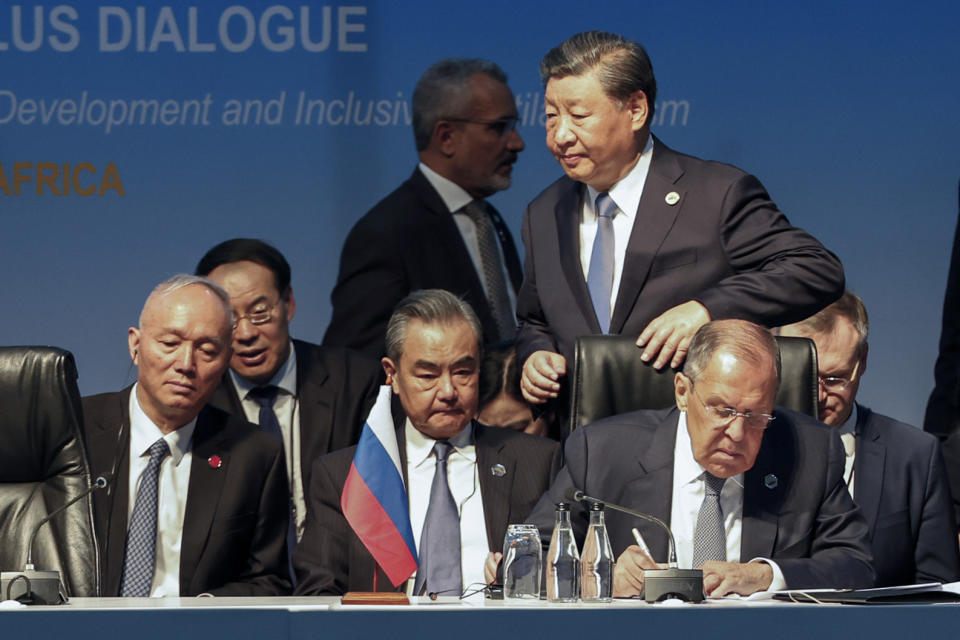 President of China Xi Jinping walks past Russia's Foreign Minister Sergei Lavrov and China's Foreign Minister Wang Yi during the 2023 BRICS Summit in Johannesburg Thursday, Aug. 24, 2023. (Marco Longari/Pool via AP)