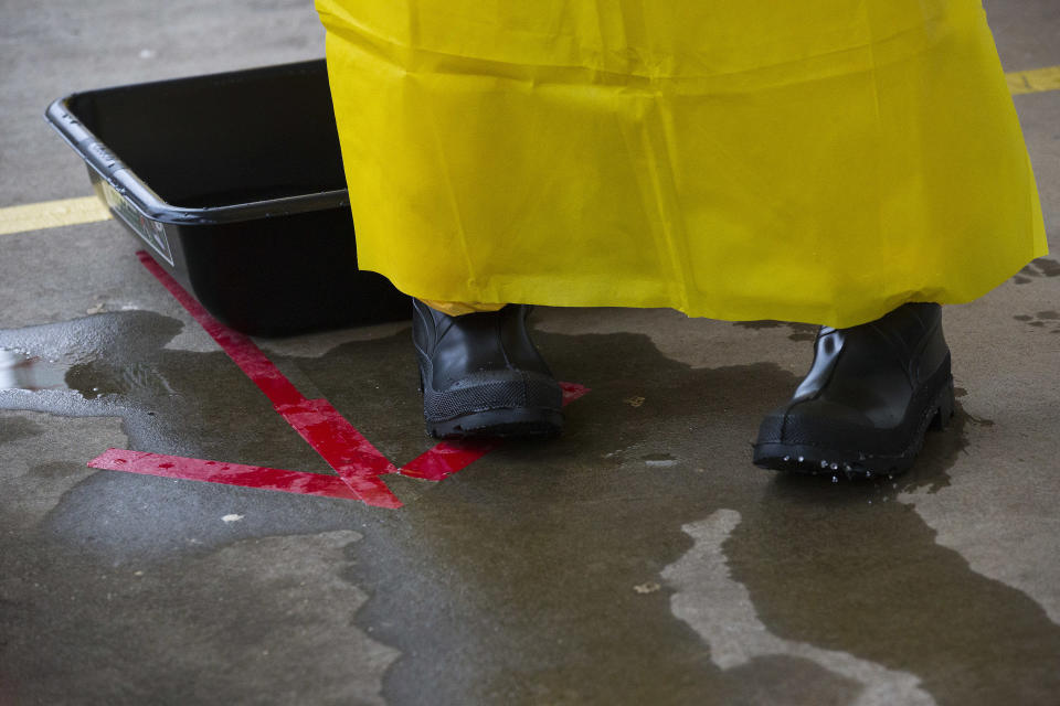 A licensed clinician exits a sanitizing bath after entering the simulated high-risk area of infected Ebola patients on Monday, Oct. 6, 2014, in Anniston, Ala. The Centers for Disease Control and Prevention (CDC) has developed an introductory training course for licensed clinicians. According to the CDC, the course is to ensure that clinicians intending to provide medical care to patients with Ebola have sufficient knowledge of the disease. (AP Photo/Brynn Anderson)