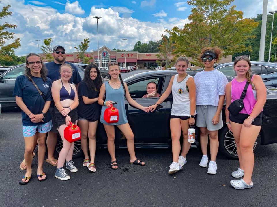 Band alum Aiden McAllister (center) seems ready to get his car washed as Assistant Band Director Chuck Brock (left) gathers several members of Hardin Valley Academy Spirit of the Valley Marching Band for the annual car wash fundraiser at Food City on Middlebrook Pike Saturday, July 22, 2023.