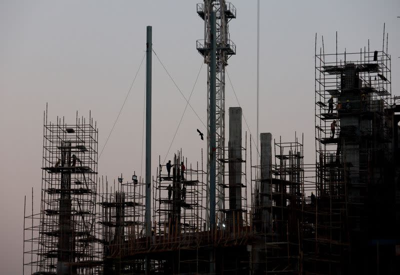 FILE PHOTO: Labourers work at the construction site of a commercial building in New Delhi