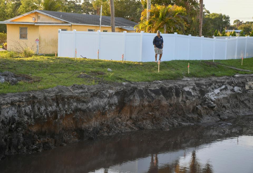 Homeowner Bonnie Cook stands by a drainage pond behind her home just off Kanner HIghway, on Thursday, Feb. 16, 2023, near Stuart. Cooke said a drainage pond created behind her home has been the cause of flooding in her house, creating mold issues in several rooms.