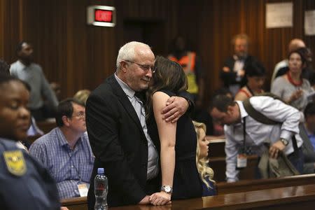 Henke Pistorius and Aimee Pistorius, the father and sister of Oscar Pistorius, embrace after the reading of the verdict by Judge Thokozila Masipa (unseen) at the North Gauteng High Court in Pretoria September 12, 2014. REUTERS/Alon Skuy/Pool