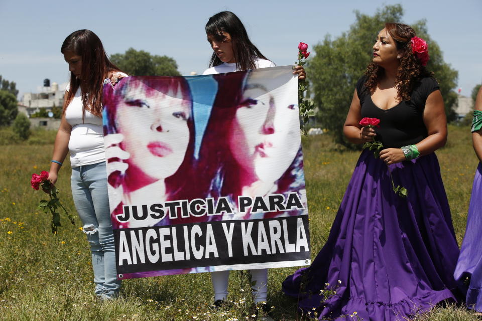 Angelica Estevez Ramirez, center, holds a poster of her mom Angelica, left side of poster, and sister Karla at the site where the two women were found murdered in April, during a vigil to protest femicide in Ecatepec, Mexico, Sunday, Oct. 6, 2019. Activists from the "Women from the Periphery for the Periphery Collective" and relatives of murdered females visited four sites where females were found dead in Ecatepec, in the state of Mexico where authorities declared in 2015 an alert concerning gender violence against women. (AP Photo/Ginnette Riquelme)