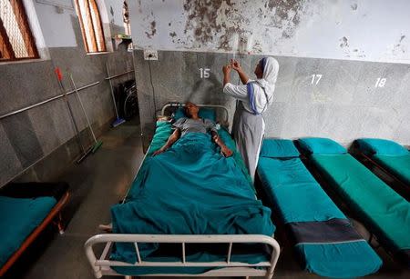 A nun belonging to the global Missionaries of Charity tends to a patient at Nirmal Hriday, a home for the destitute and old, founded by Mother Teresa ahead of Mother Teresa's canonisation ceremony, in Kolkata, India, August 31, 2016. REUTERS/Rupak De Chowdhuri