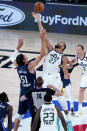 Utah Jazz's Rudy Gobert (27) and Dallas Mavericks' Boban Marjanovic (51) leap for a jump ball to start an NBA basketball game Monday, Aug. 10, 2020, in Lake Buena Vista, Fla. (AP Photo/Ashley Landis, Pool)