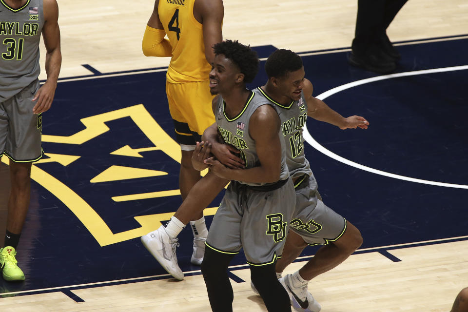 Baylor guards Adam Flagler and Jared Butler (12) celebrate the team's win over West Virginia in an NCAA college basketball game Tuesday, March 2, 2021, in Morgantown, W.Va. (AP Photo/Kathleen Batten)