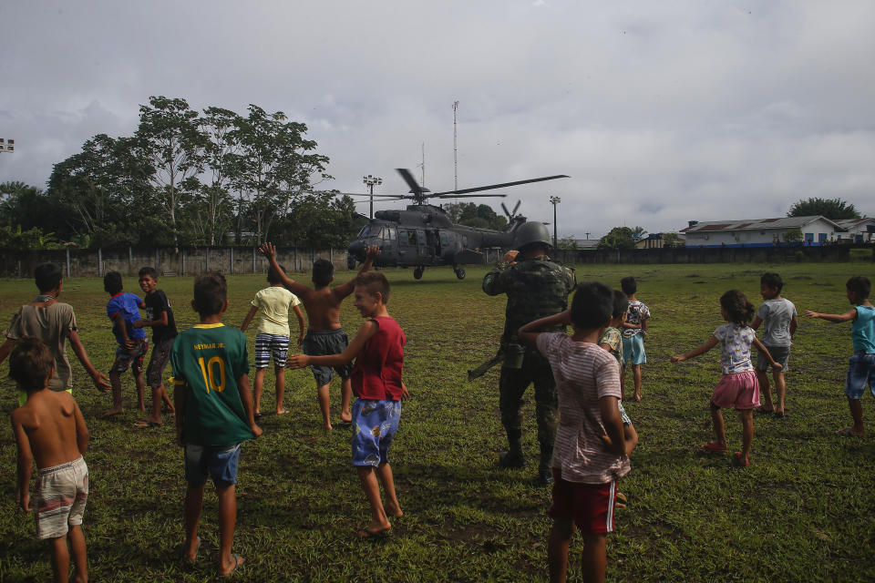 Children watch an army helicopter prepare for liftoff to search for missing British journalist Dom Phillips and Indigenous affairs expert Bruno Araujo Pereira in the Javari Valley Indigenous territory, Atalaia do Norte, Amazonas state, Brazil, Friday, June 10, 2022. Phillips and Pereira were last seen on Sunday morning in the Javari Valley, Brazil's second-largest Indigenous territory which sits in an isolated area bordering Peru and Colombia. (AP Photo/Edmar Barros)