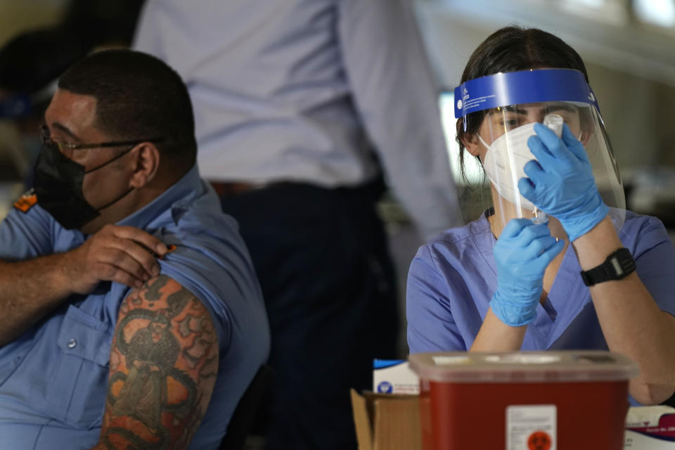 Medical personnel prepare a coronavirus vaccine to be administered to New York City firefighter emergency medical services personnel at the FDNY Fire Academy in New York, Wednesday, Dec. 23, 2020. (AP Photo/Seth Wenig)