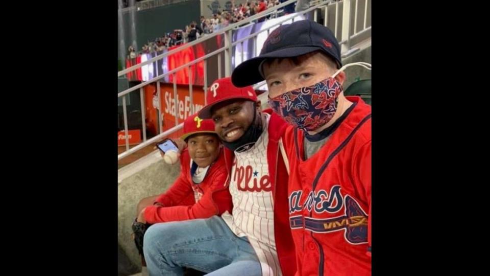 Phillies fans Joshua Scott, left, and his dad, James, capture a special moment with a boy they met during a Braves-Phillies game in Atlanta on Friday, April 9, 2021. Josh gave the boy a home run ball hit by Braves star Freddie Freeman. The Scotts are from Charlotte.