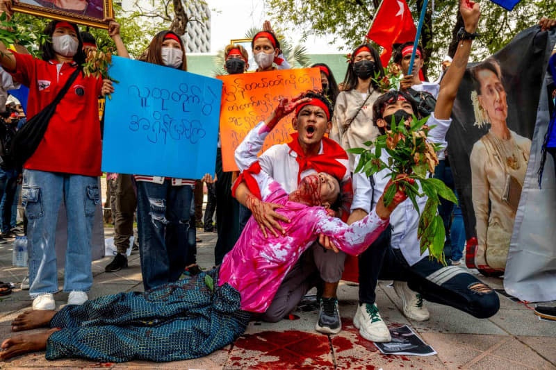 A protester covered in fake blood stages a die-in next to an image of detained civilian leader Aung San Suu Kyi during a demonstration outside the UN office in Bangkok, to mark the third anniversary of the coup in Myanmar. Adryel Talamantes/ZUMA Press Wire/dpa