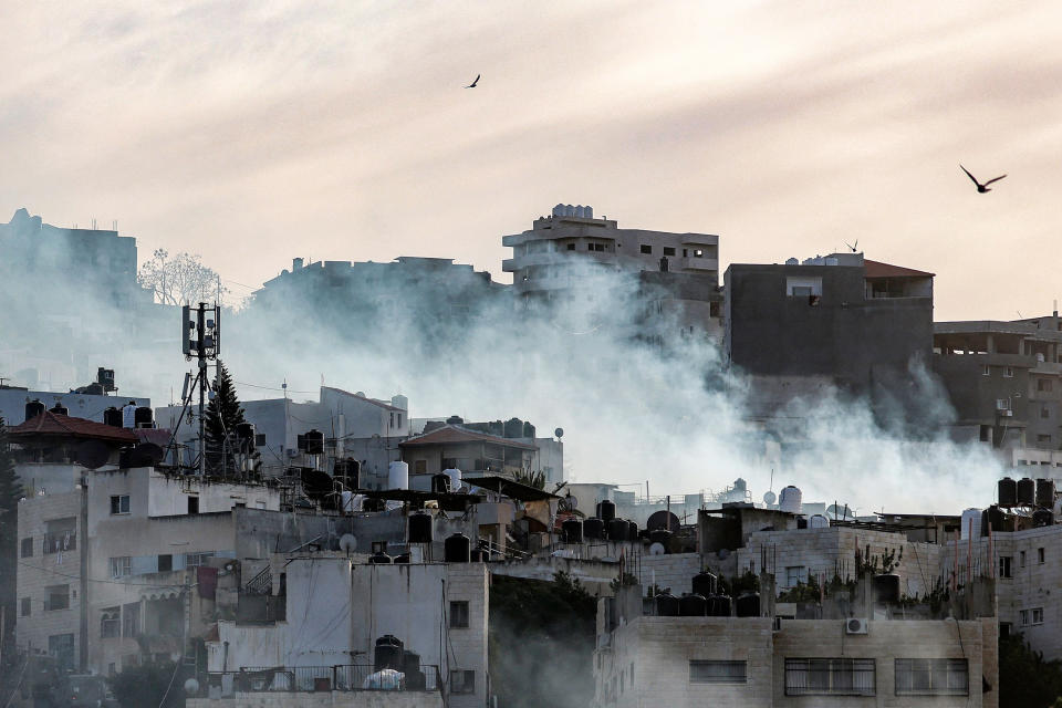 Birds fly as smoke plumes billow during an Israeli army raid in the Jenin camp for Palestinian refugees in the occupied West Bank on March 7, 2023. - Israeli troops killed six Palestinians in Jenin on March 7, including an alleged militant accused of killing two Israelis. The Palestinian health ministry said six men had been killed, one aged 49 and the rest in their 20s, in clashes that the army said included soldiers launching shoulder-fired rockets amid ferocious gunfire. (Jaafar Ashtiyeh / AFP - Getty Images)