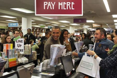 U.S. President Barack Obama and his daughters Sasha (center L) and Malia (center R) shop at Politics and Prose bookstore in Washington November 29, 2014. REUTERS/Yuri Gripas