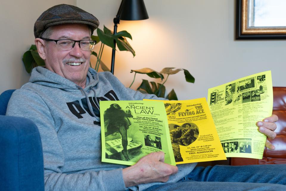 Bill Shaffer, Kansas Silent Film director, holds up posters for this year's films that will be shown at the festival Feb. 23-25 at White Concert Hall.