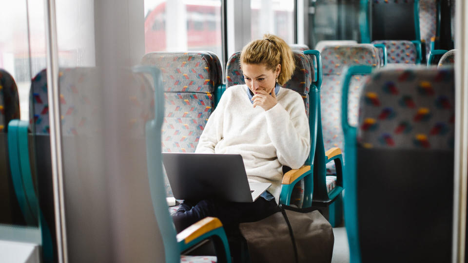Young Woman Commuting by Train, Using Laptop.