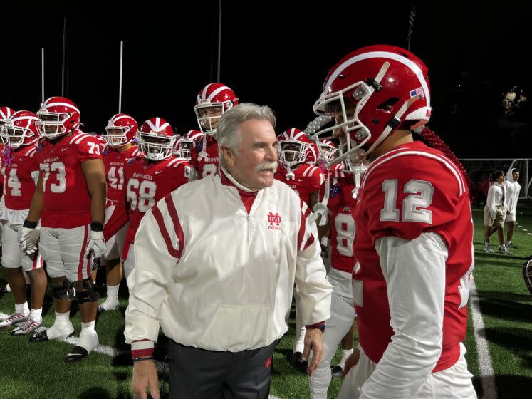 Mater Dei coach Bruce Rollinson speaks to quarterback Elijah Brown before Friday's playoff game against JSerra.