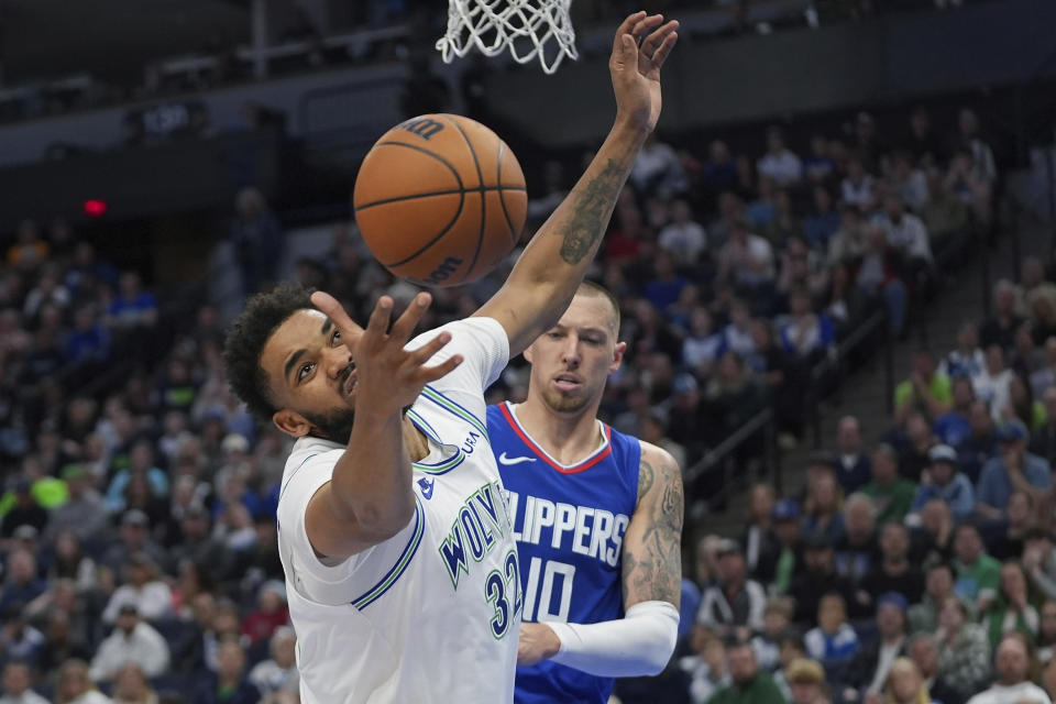 Minnesota Timberwolves center Karl-Anthony Towns (32) loses control of the basketball as Los Angeles Clippers center Daniel Theis (10) defends during the second half of an NBA basketball game, Sunday, March 3, 2024, in Minneapolis. (AP Photo/Abbie Parr)