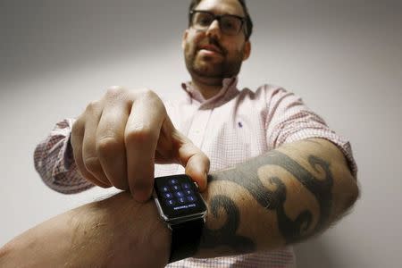 Reuters journalist Matt Siegel inputs his passcode onto his Apple Watch as his tattoos prevent the device's sensors from correctly detecting his skin, in Sydney, Australia, April 30, 2015. REUTERS/Jason Reed