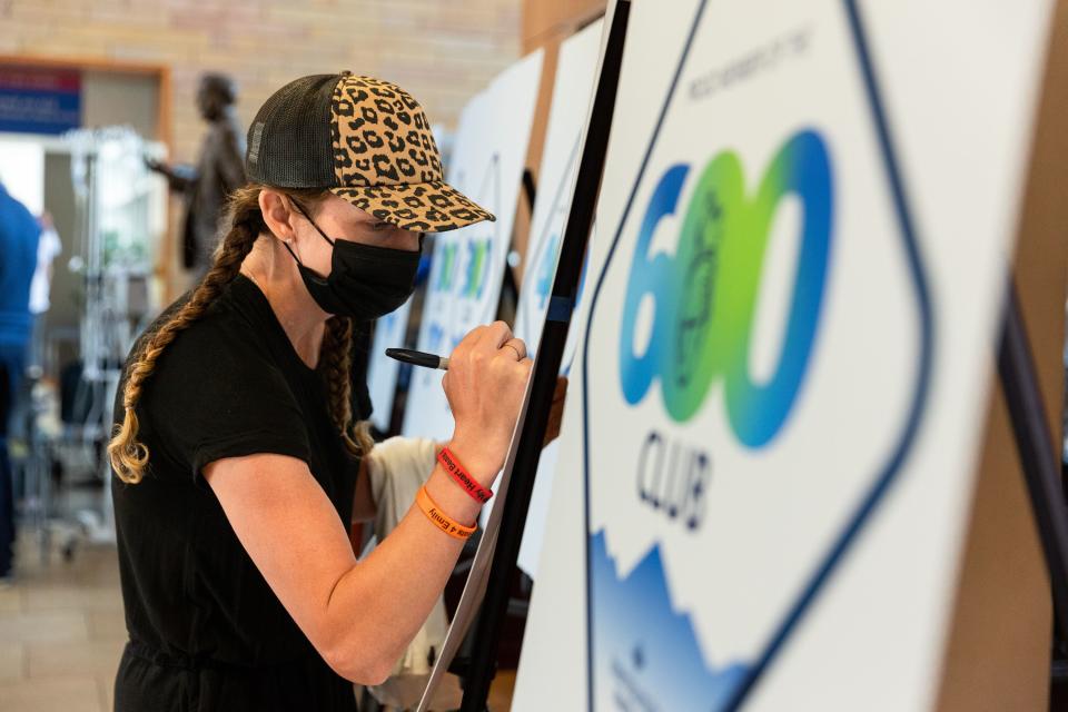 Emily Evans signs the 500 Club poster at an event held to celebrate the milestone of 600 lifesaving transplants by the Intermountain heart transplant team at the Intermountain Medical Center in Murray on Tuesday, July 18, 2023. | Megan Nielsen, Deseret News