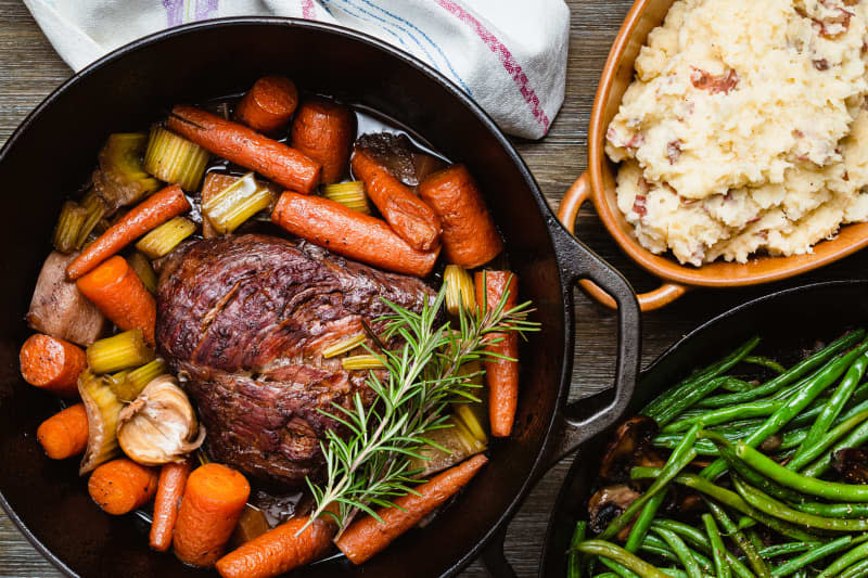 Pot roast in a cast iron dutch oven, green beans and mashed potato.