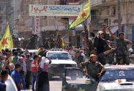 Kurdish People's Protection Units (YPG) fighters parade in the Syrian town of Qamishli after returning from battling Islamic State group jihadists on the border with Turkey on June 24, 2015