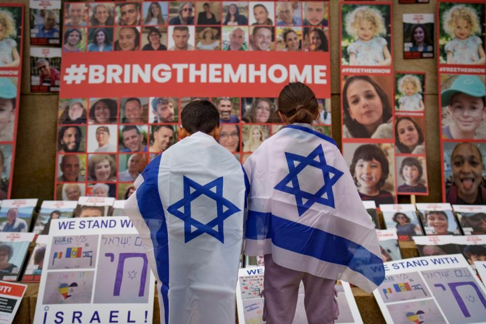 Children look at photographs of Israelis kidnapped by Hamas during a rally joined by hundreds in solidarity with Israel and those held hostage in Gaza (AP)