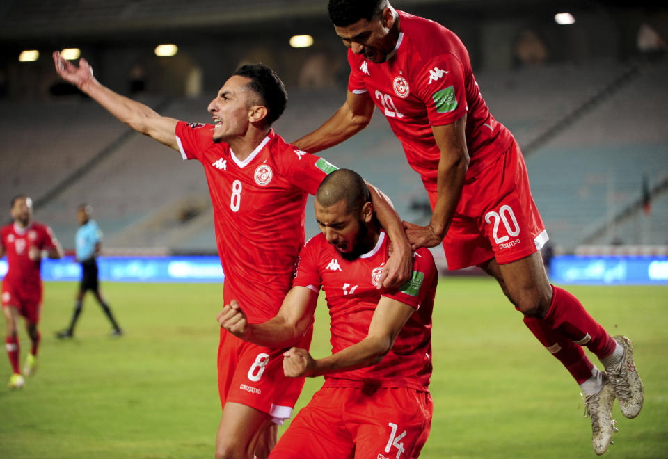 ARCHIVO - Los jugadores tunecinos Aissa Bilal Laidouni (centro), Mohamed Drager (derecha) y Saif Eddine Khaoui celebra tras anotar un gol ante Zambia en las eliminatorias del Mundial en Túnez, el 16 de noviembre de 2021. (AP Foto/Hassene Dridi)
