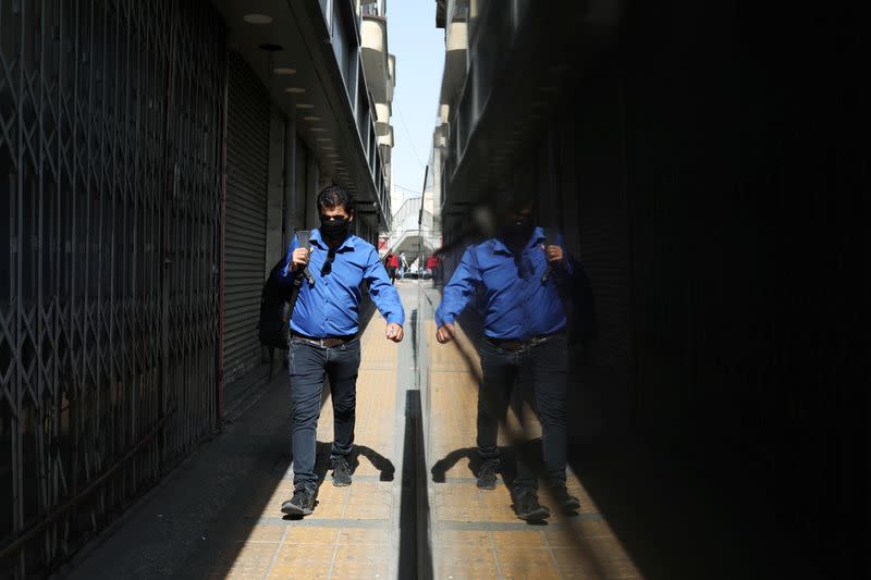 A man wearing a protective face mask walks a street, following the outbreak of the coronavirus disease (COVID-19), in Tehran