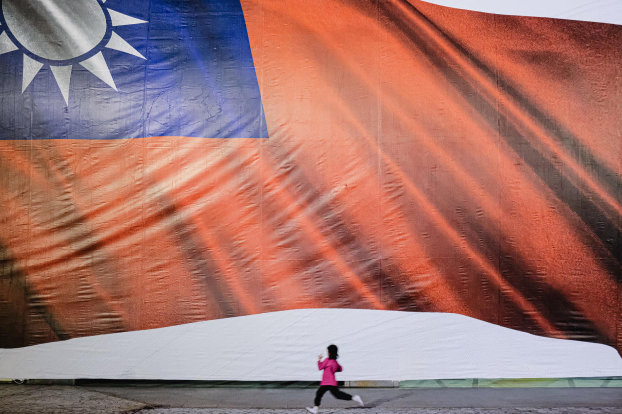 A child runs across the flag of Taiwan banner during the announcement of official results  in Taipei, Taiwan on Jan. 13, 2024.  (Sawayasu Tsuji / Getty Images)