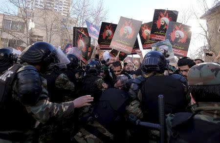 Protesters holding pictures of Shi'ite cleric Sheikh Nimr al-Nimr are pushed back by Iranian riot police during a demonstration against the execution of Nimr in Saudi Arabia, outside the Saudi Arabian Embassy in Tehran January, 3, 2016. REUTERS/Raheb Homavandi/TIMA